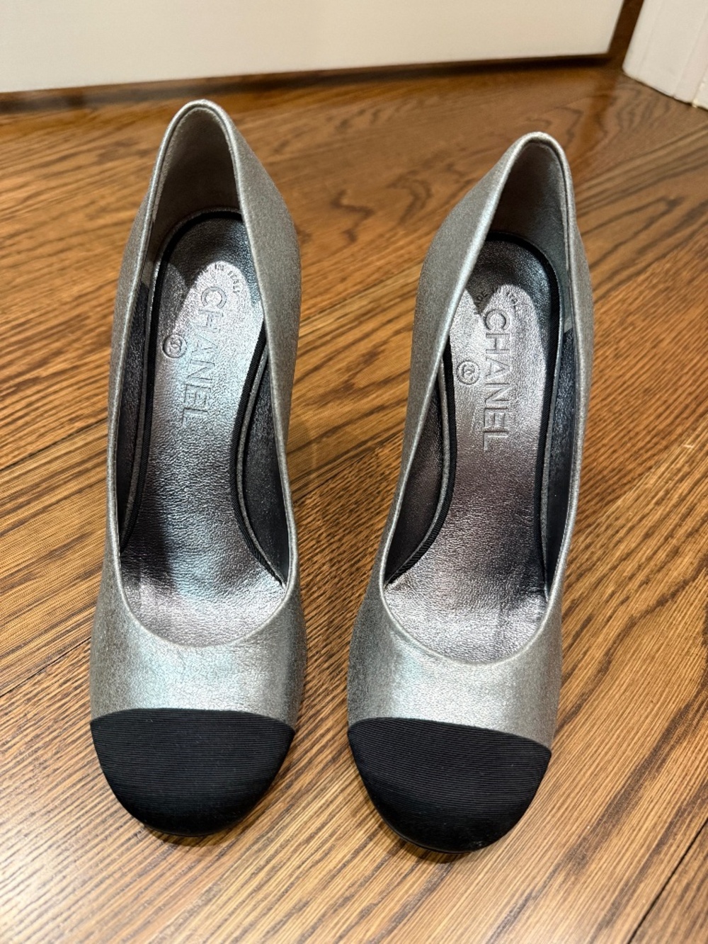 Chanel metallic silver leather pumps featuring a black cap round toe